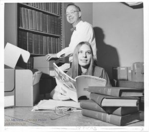 Photograph of two archivists with archival materials.