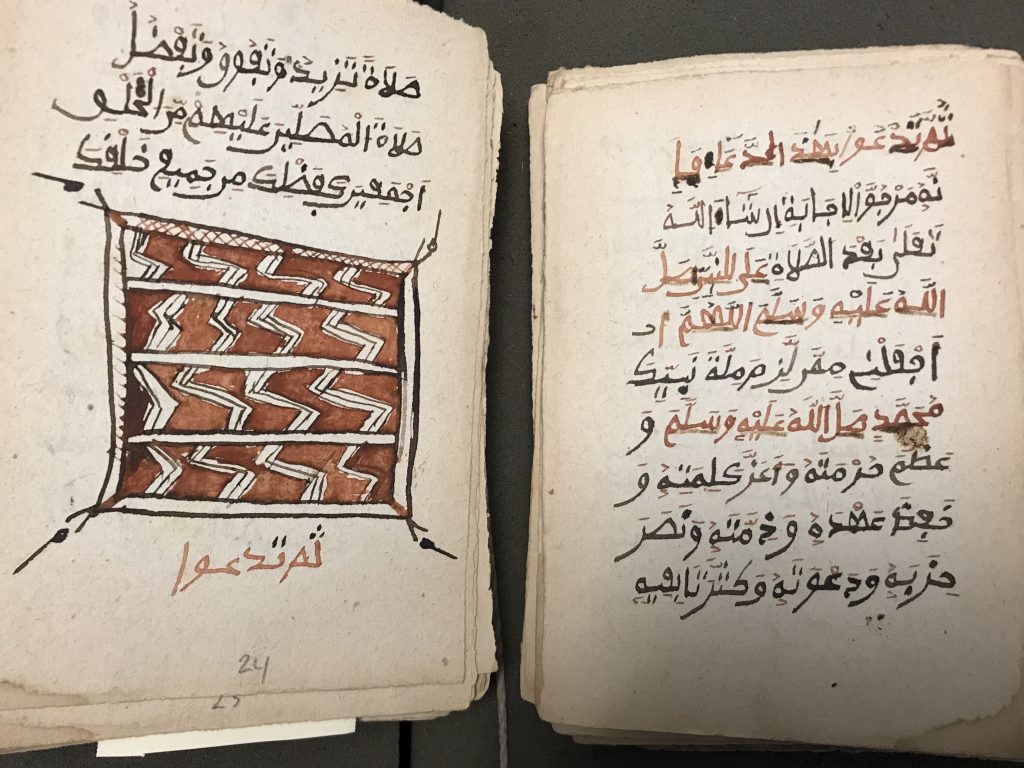 An open page of an Arabic manuscript with a drawing and red and black text