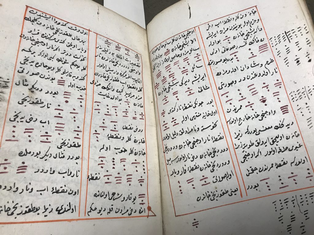 An open two page spread of an Arabic manuscript. The text is in two columns with red boxes surrounding it.