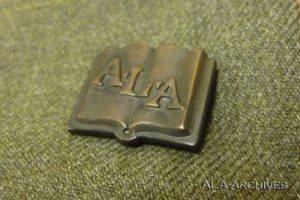 Open book pin on green background.