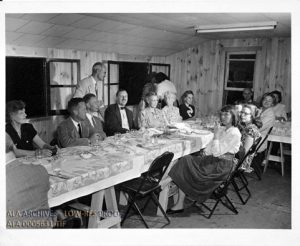 People sitting at tables with dinner.