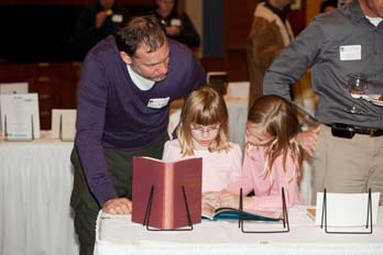 Several faculty brought their children to celebrate in their achievements Here a family inspects Prof Miraftab's selection - The Rain Came Down by David Shannon