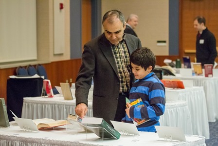 Several faculty brought their children to celebrate in their achievements. Here, an honoree inspects a selection with his son