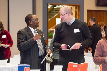 Provost Ilesanmi Adesida discusses a bookplate selection with an honoree