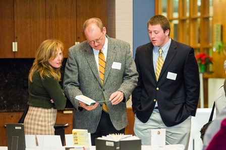 An honoree and his family browse the books selected by promoted and tenured faculty