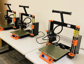 Three Prusa 3D printers on a work table