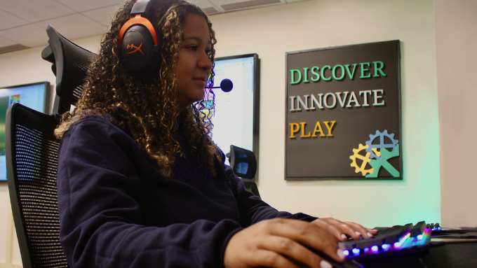 A woman wearing headphones playing computer games.