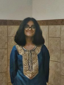 Anvi standing and smiling at the camera.