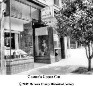 black and white photo of the entrance to a barbarshop on a city sidewalk