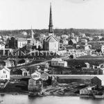1871 East Elgin Panorama Looking at east Elgin along the Fox Riverbank. The Congregational Church is in the center of the photograph with the First Universalist Church to the left with four short steeples. Behind the Universalist Church is the Old Stone Baptist Church a small steeple.
