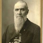 Black and white photo of Robert Oliver, a full-bearded gentleman wearing a dark coat and several medals.