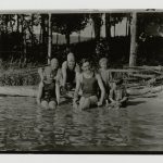 Black and white photo of the Hemingway siblings gathered on the shore of a lake.