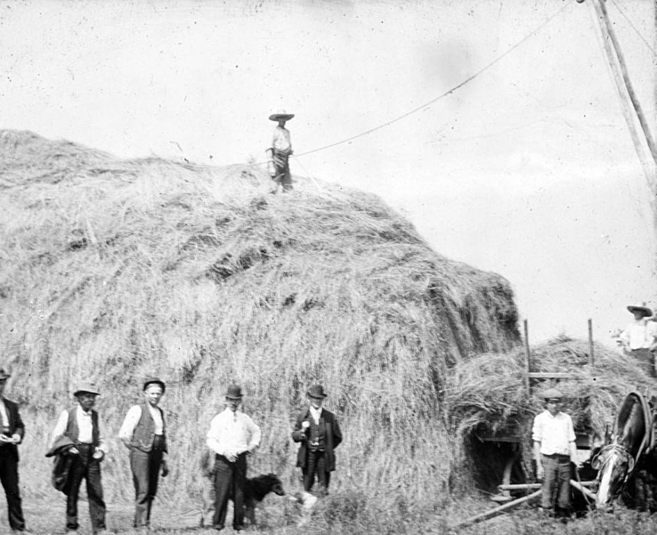 Group_of_Men_Standing_Near_a_Bale_of_Hay