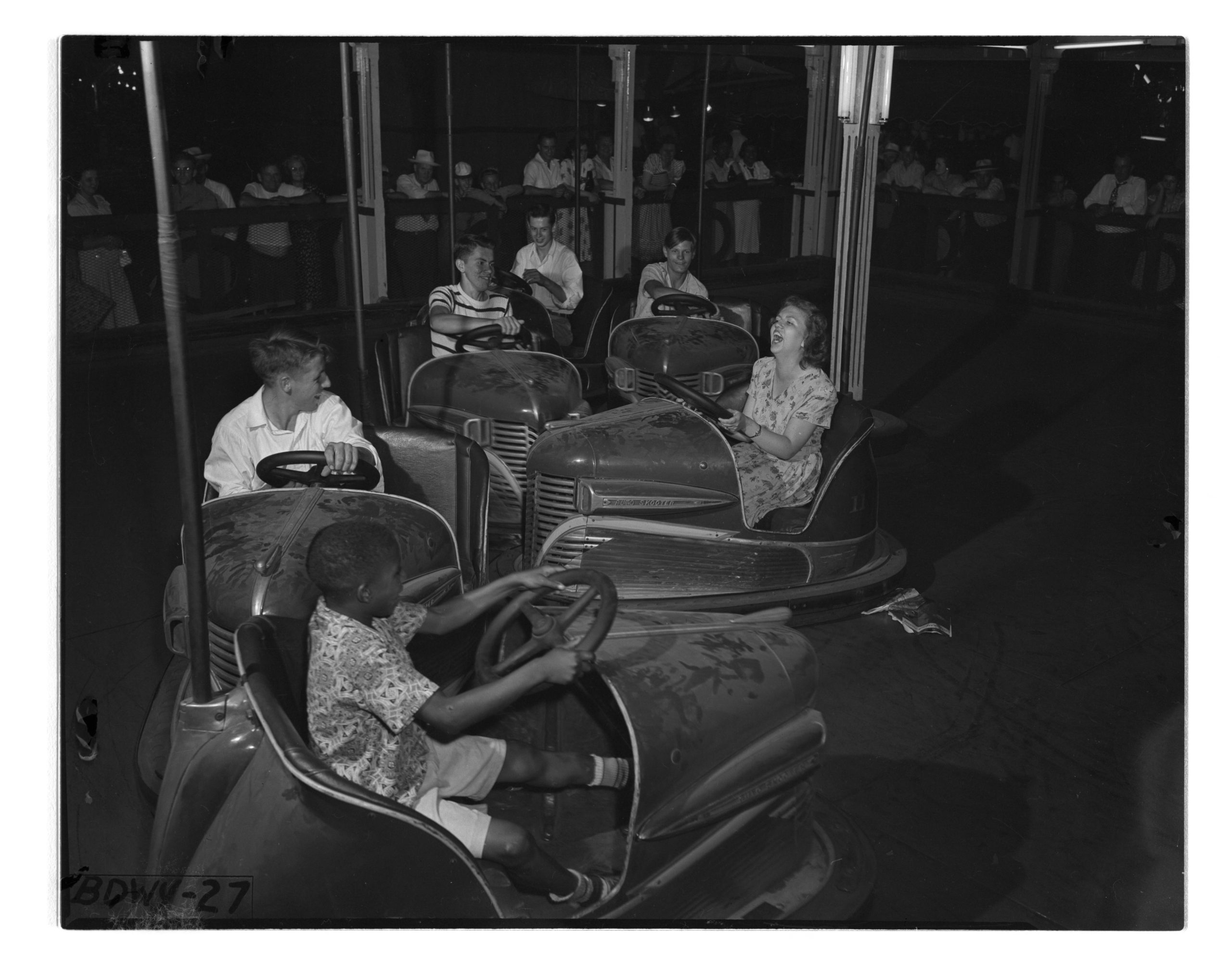 black and white image of 1950s bumper cars bumping into each other