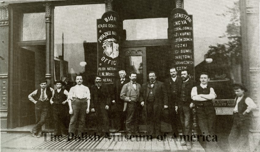 Image depicting workers in front of the entrance of Zgoda print shop and PNA building at 1414 (then 112) W. Division St., Chicago; 1889.