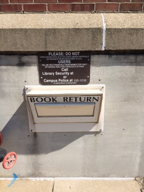 Book return slot located in the southwest parking lot of the Main Library.