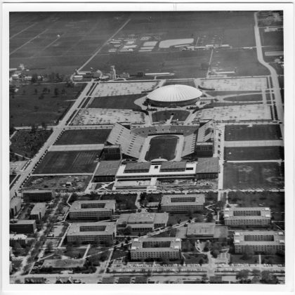 Aerial view, towards the south, of facilities located on the south campus of the University, including, from near to far, the Men's Residence Halls, the Intramural and Physical Education Building (IMPE), Memorial Stadium, Assembly Hall, the Sheep and Beef Cattle facilities, the research farms in the distance, May 1971