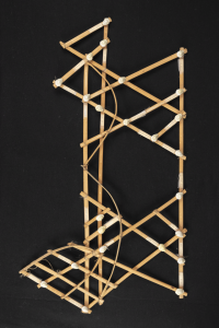 Stick chart of the Marshall Islands made of strips of coconut or palm wood, cowrie shells, and fishing line and and showing islands (represented by shells) connected by currents and wave patterns (represented by the strips of wood).