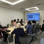 2024 Associates sitting listening to a speaker