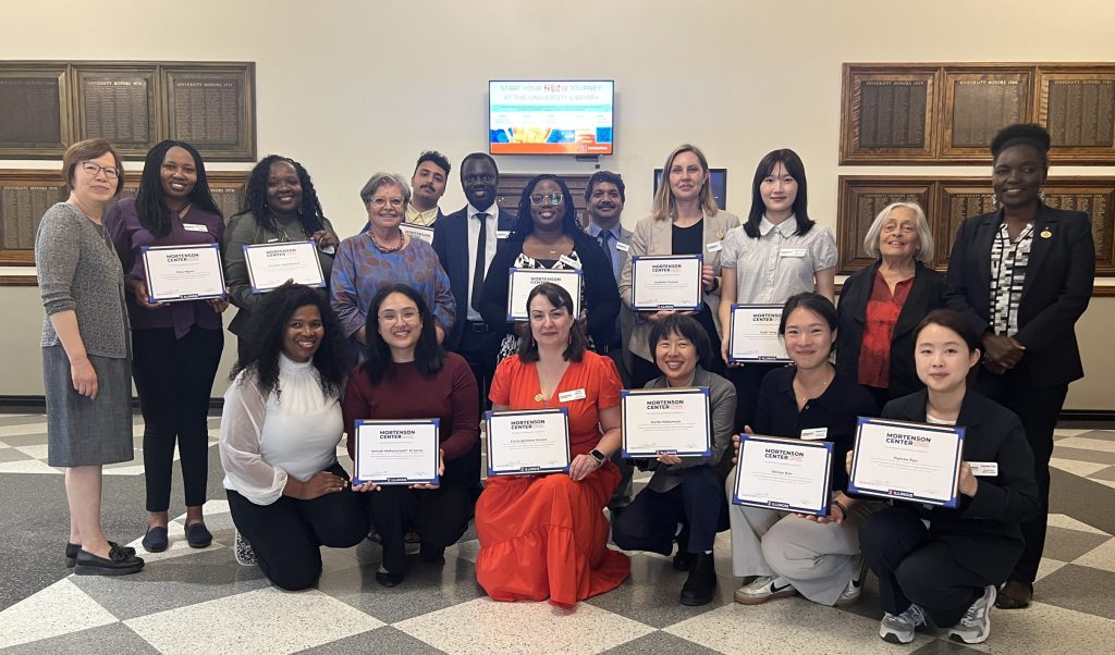 The Mortenson Center Class of 2026 holding their graduation certificates together with the Mortenson Center Associates Team.