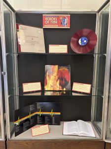 Exhibit case featuring various vinyl records and one book. The items included highlight underrepresented voices, shellac discs, the first stereo recordings, and quadraphonic sound. 