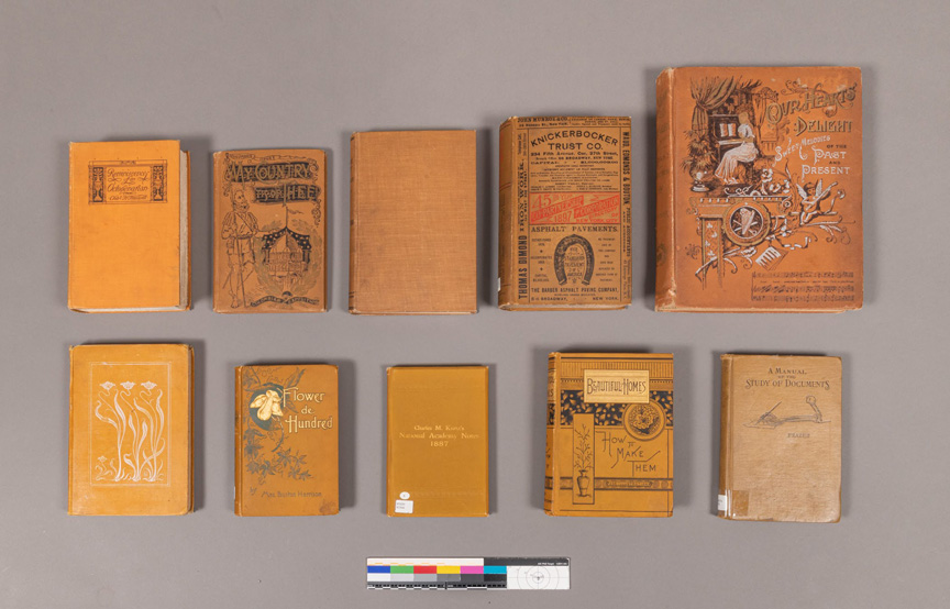 Nine different Victorian-Era books with yellow and orange cloth, with front covers ranging from plain to highly decorative stamping and illustrations.