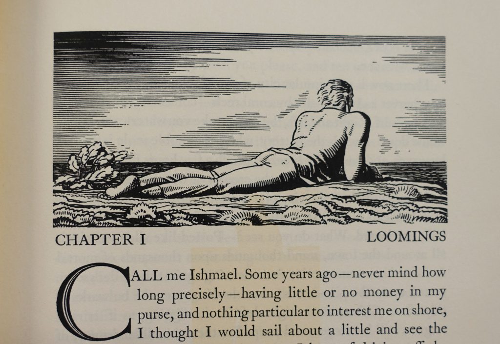 The illustration at the top of the first page of Moby-Dick, depicting from behind a man laying on a cliff looking out at the ocean. The first lines of the chapter are visible below.