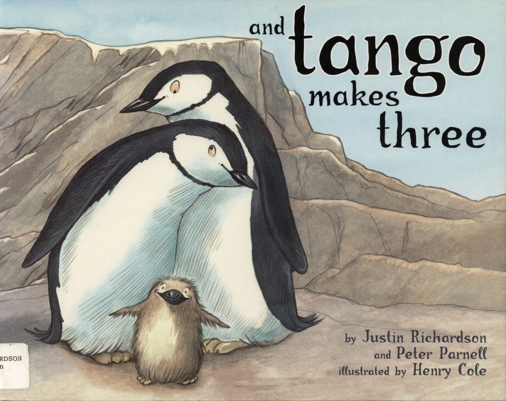 The front cover of And Tango Makes Three. It shows two adult penguins with their chick.