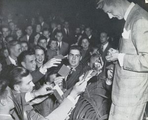Band leader Johnny Long signs autographs for U of I students in 1937. That year, the dance was so popular a second had to be scheduled.