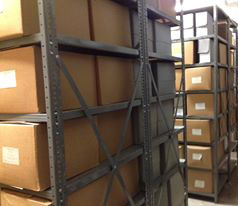 Shows metal shelving and archival boxes in storage vault, to show potential donors how the Student Life and Culture Archives stores their material.