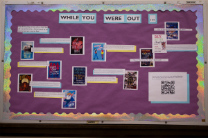 Picture of a hallway display in the Uni building, featuring books like "A Phoenix Must Burn" and "The Vanishing Deep"