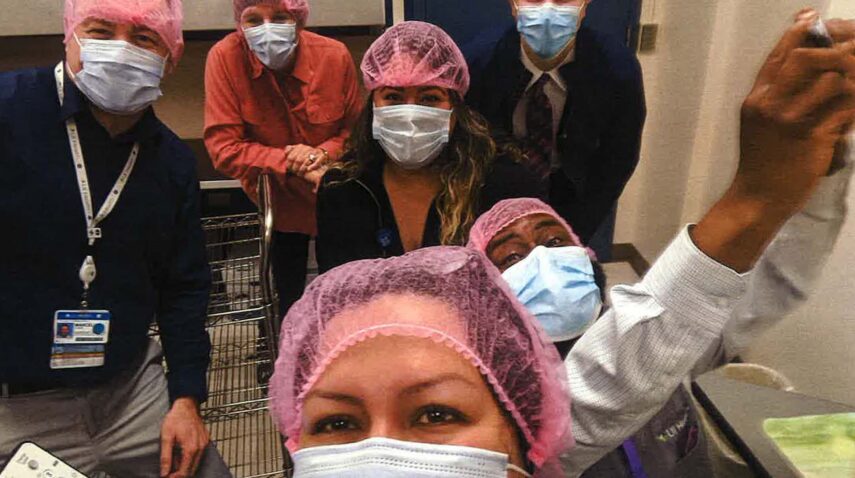 Six people wearing surgical face masks and hairnets.