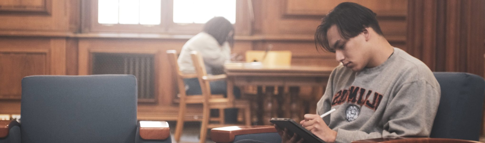 Decorative: two students studying separately in Main Library Room 204
